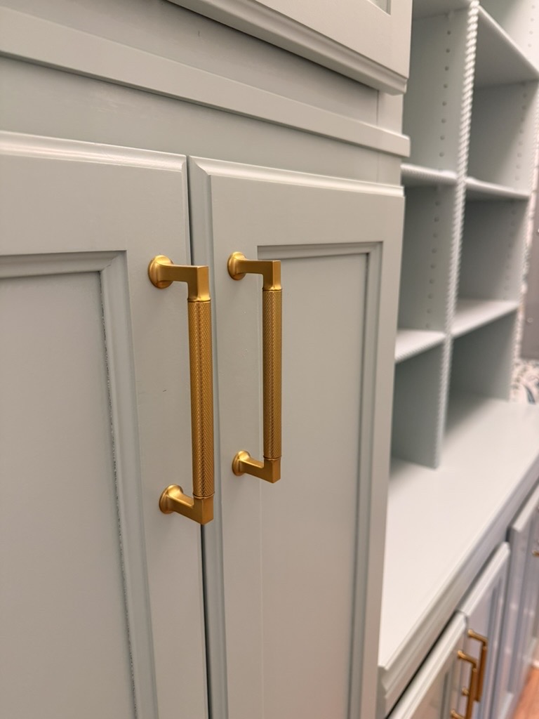 Brushed brass hardware on sage built-in cabinetry
