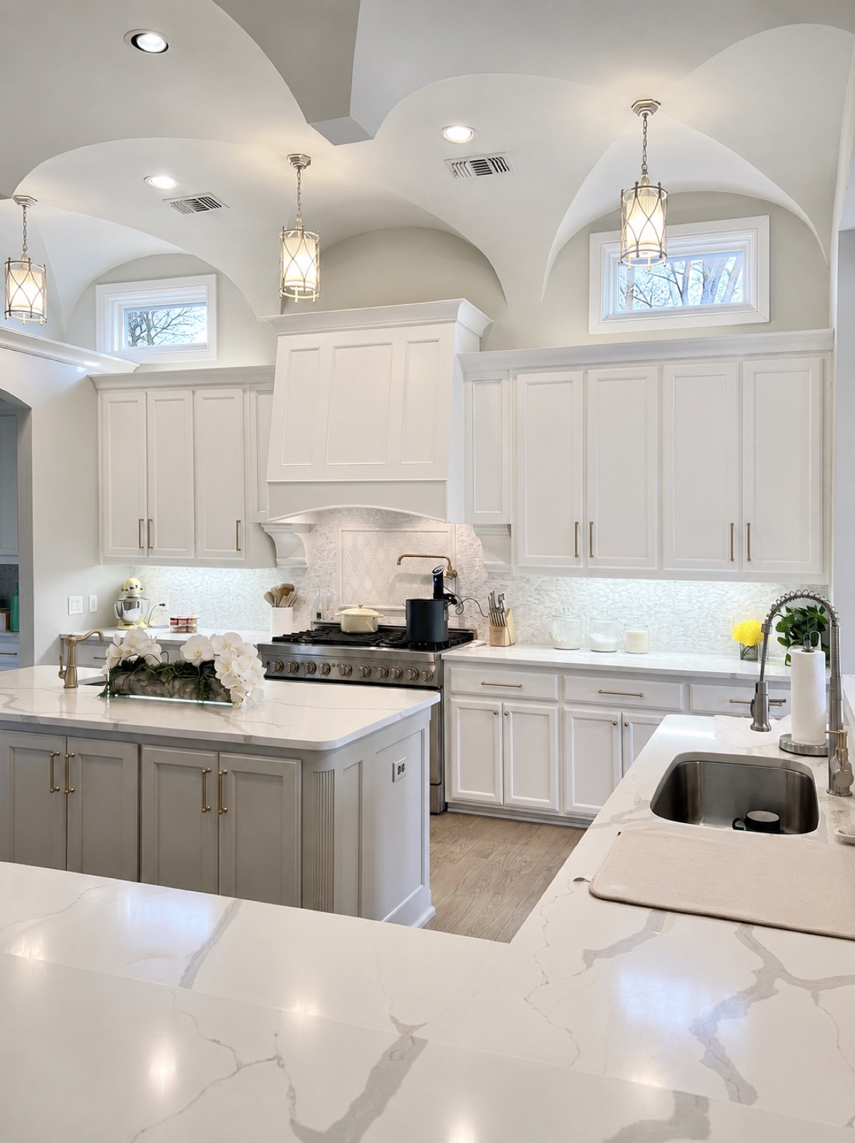 White kitchen with arched ceiling details and lantern pendants